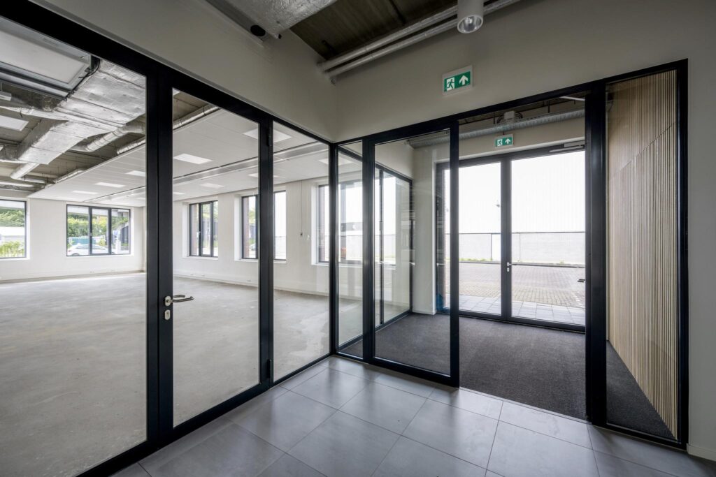 Modern glass entrance and empty office space at Paul van Vlissingenstraat.